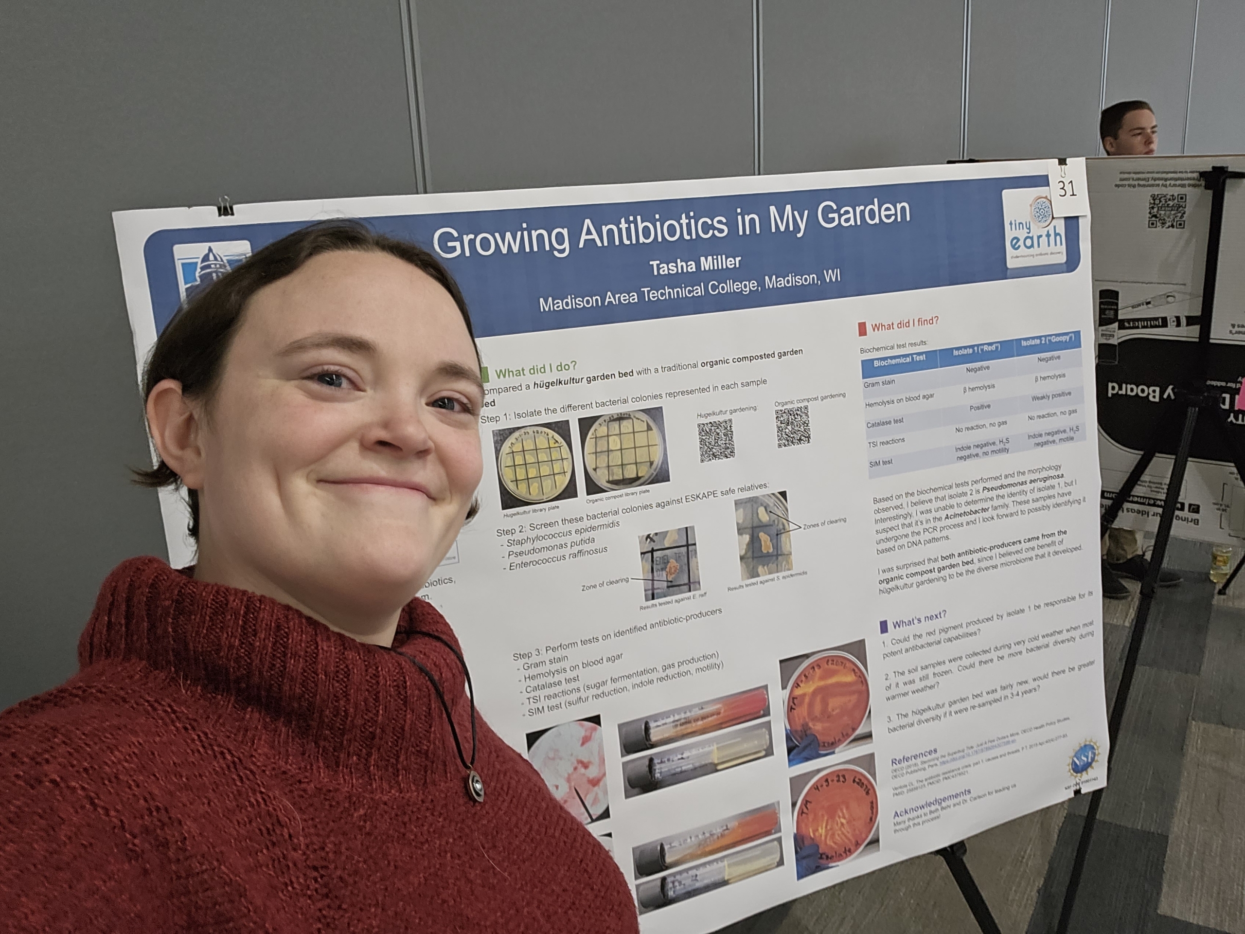 Tasha Miller taking a selfie in front of her research poster.